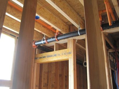A pipe is hanging from the ceiling of a building under construction.
