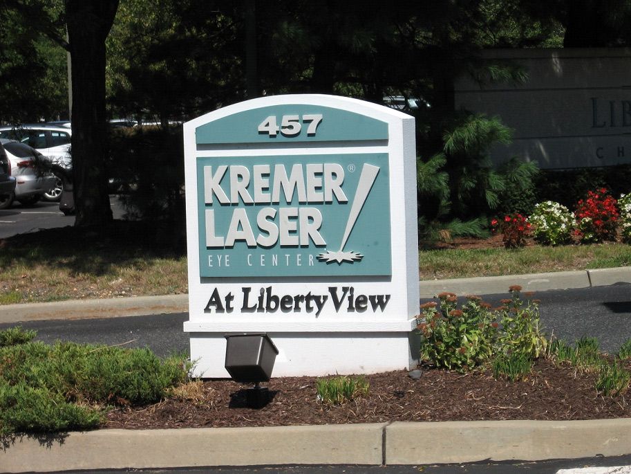 A green and white sign for Kremer Laser at Liberty View