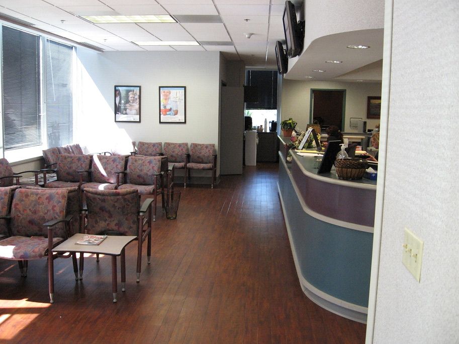 A waiting room with lots of chairs and a counter