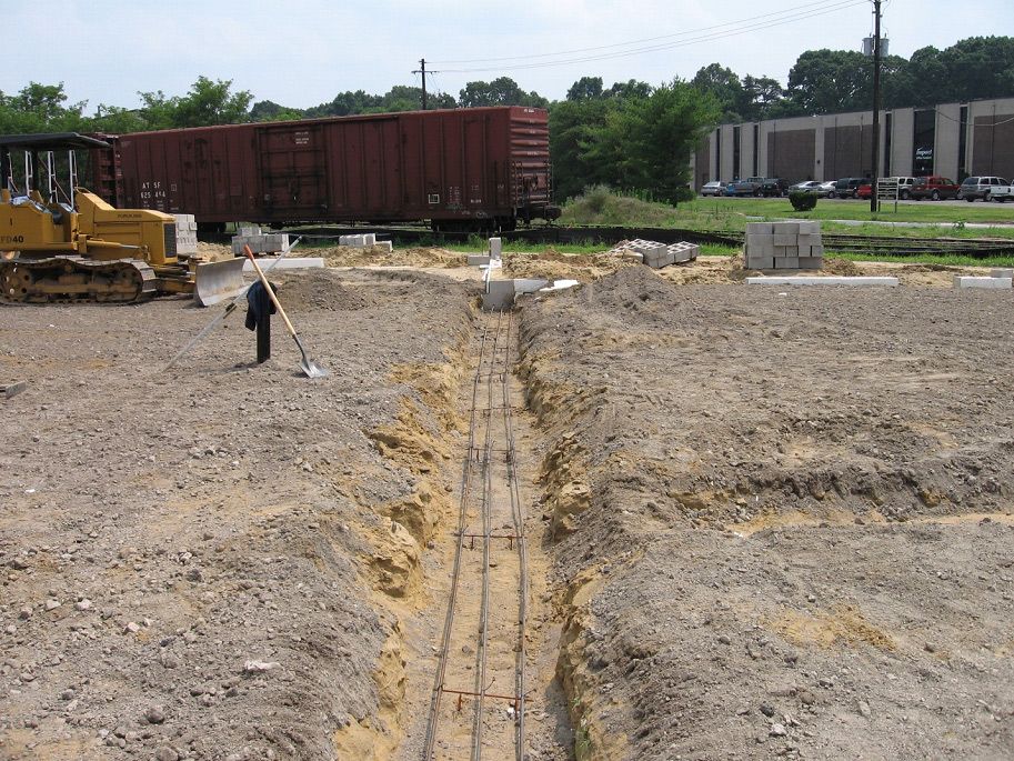 A construction site with a train in the background and a bulldozer in the foreground