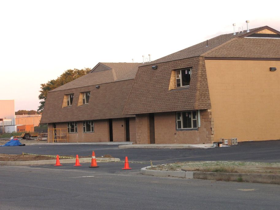 A building under construction with a lot of orange cones in front of it