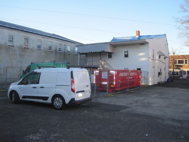 A white van is parked in front of a building.