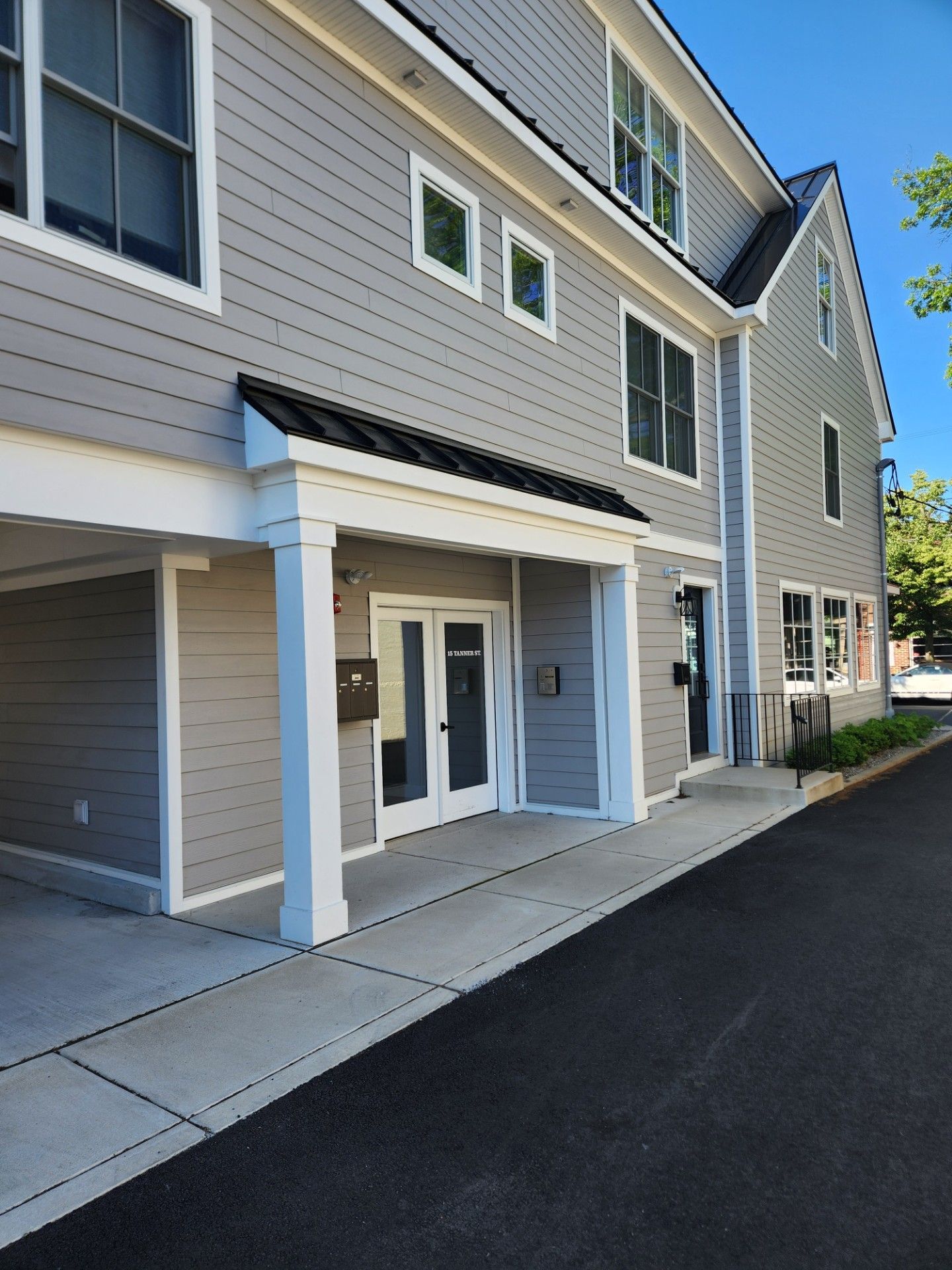 A building with a porch and a mailbox on the side of it.