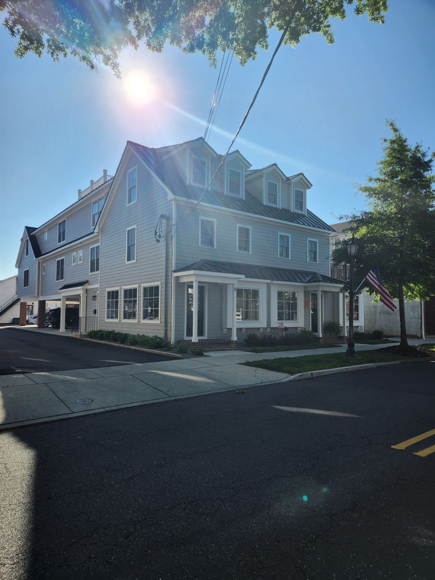 A large white house is on the corner of a street.
