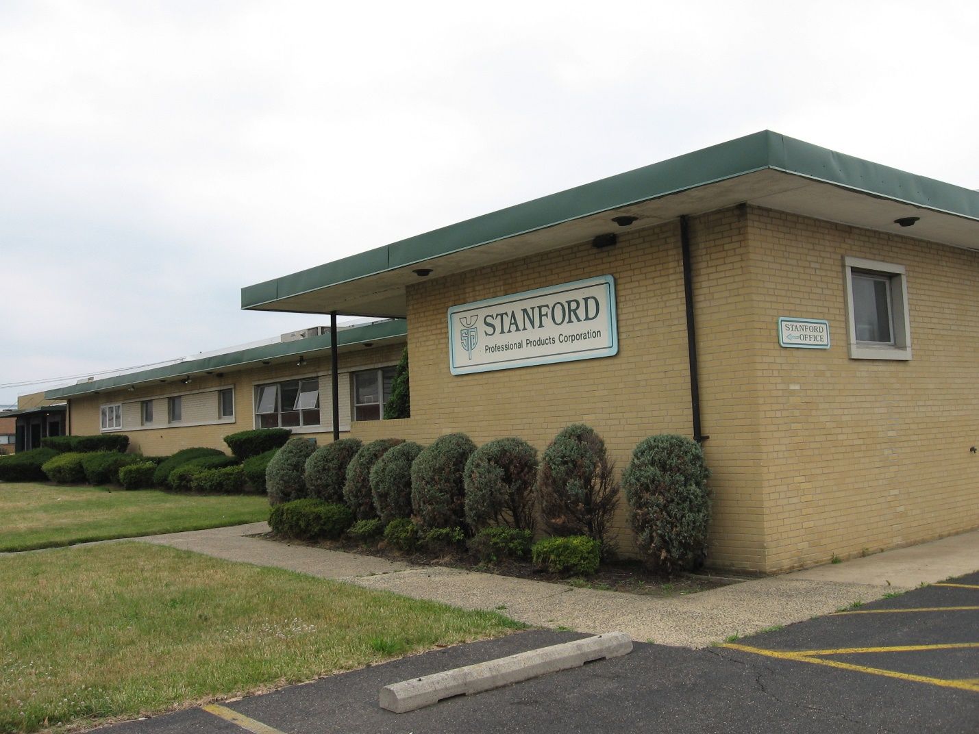 A brick building with a green roof and a sign that says stakeford.