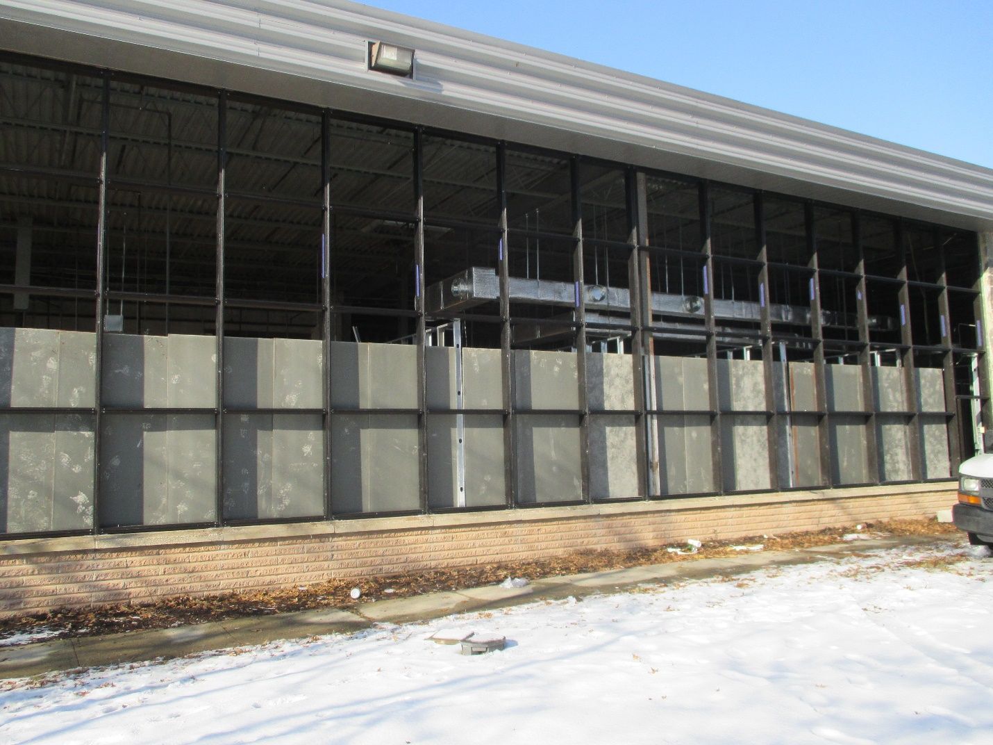 A car is parked in front of a building with a lot of windows.