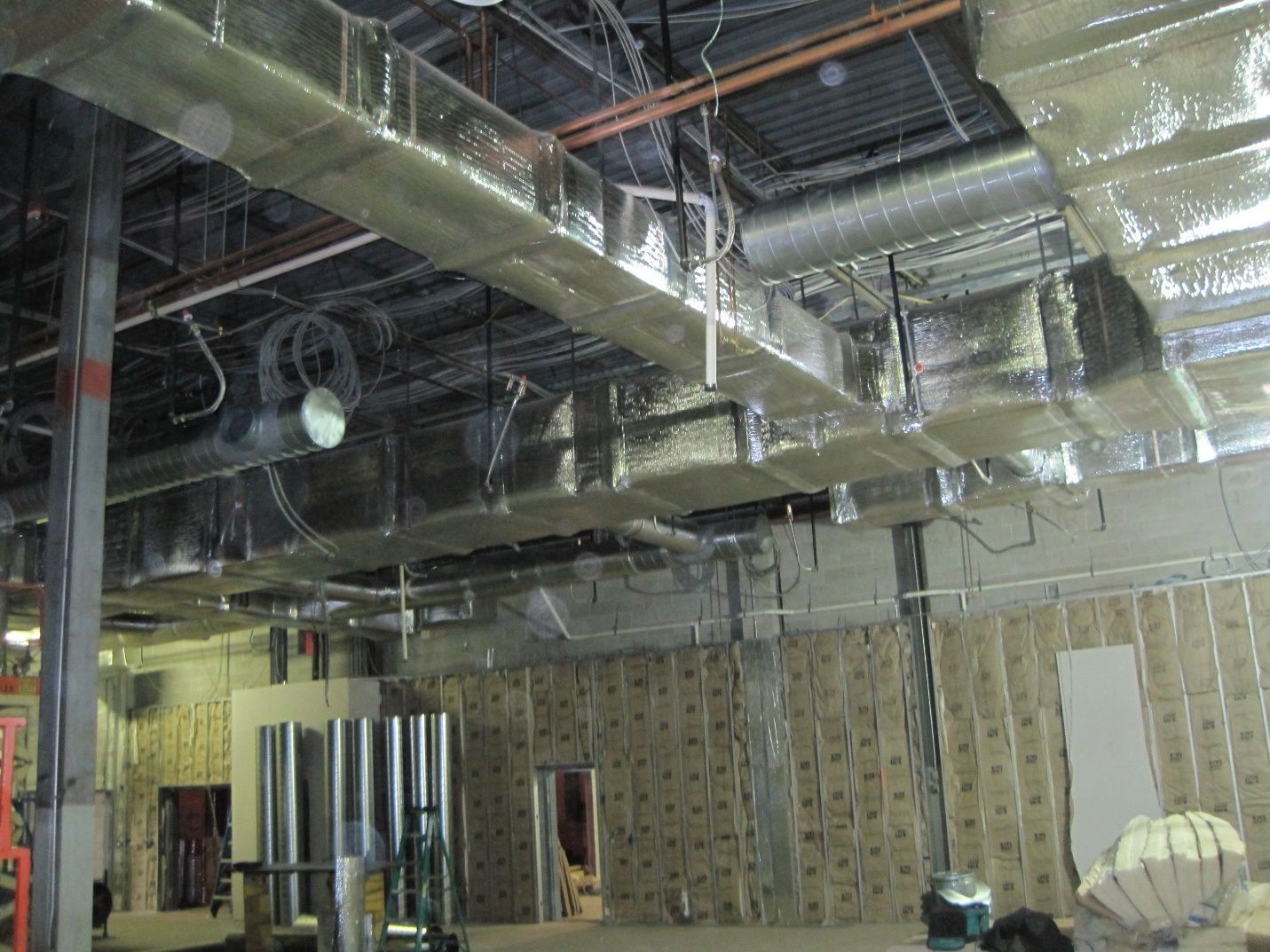 A large room with a lot of pipes hanging from the ceiling.