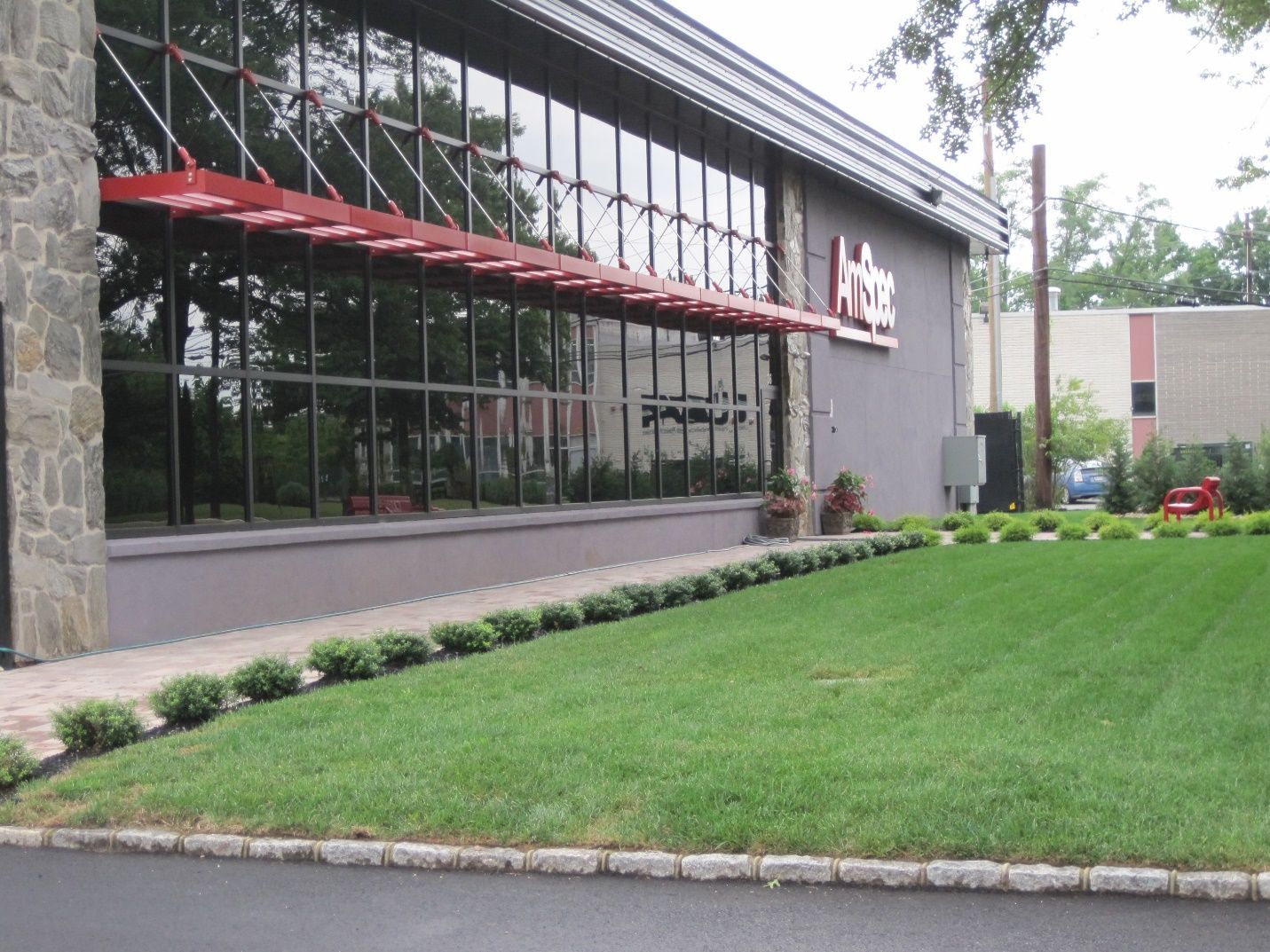 A large building with a lot of windows and a red awning.
