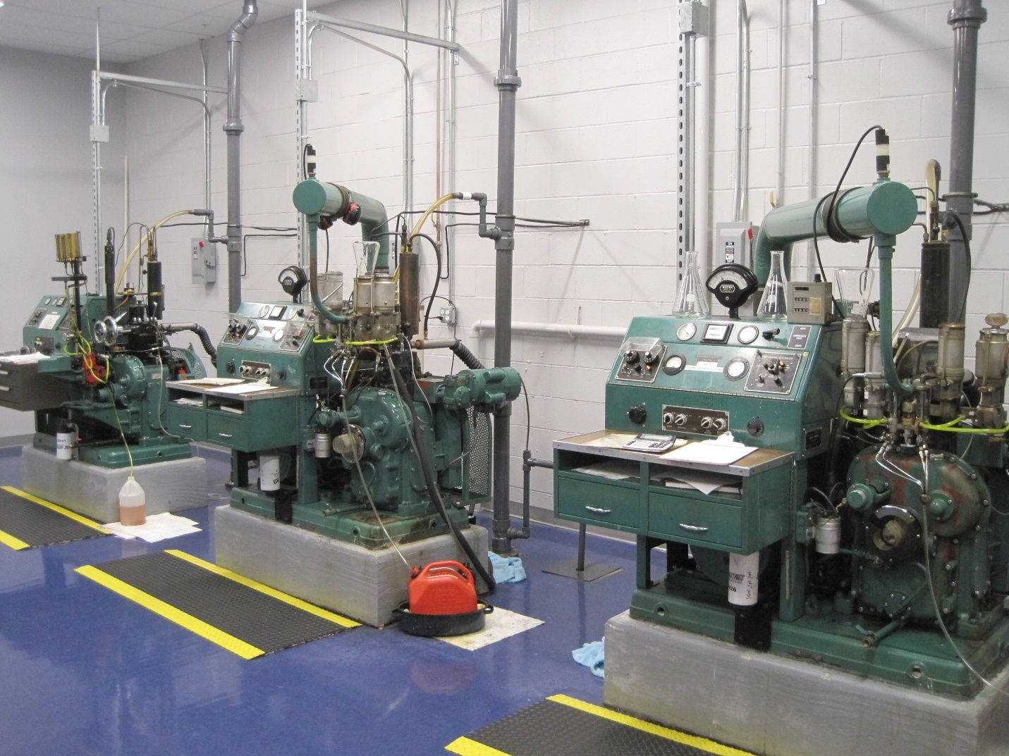 A row of green machines are lined up in a room.