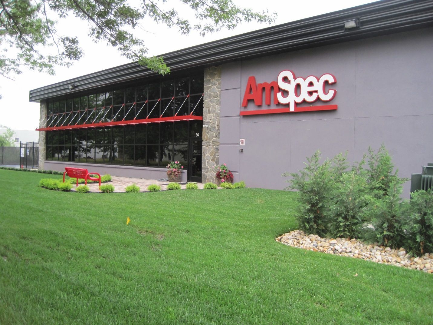 An art spec building with a lush green lawn in front of it.