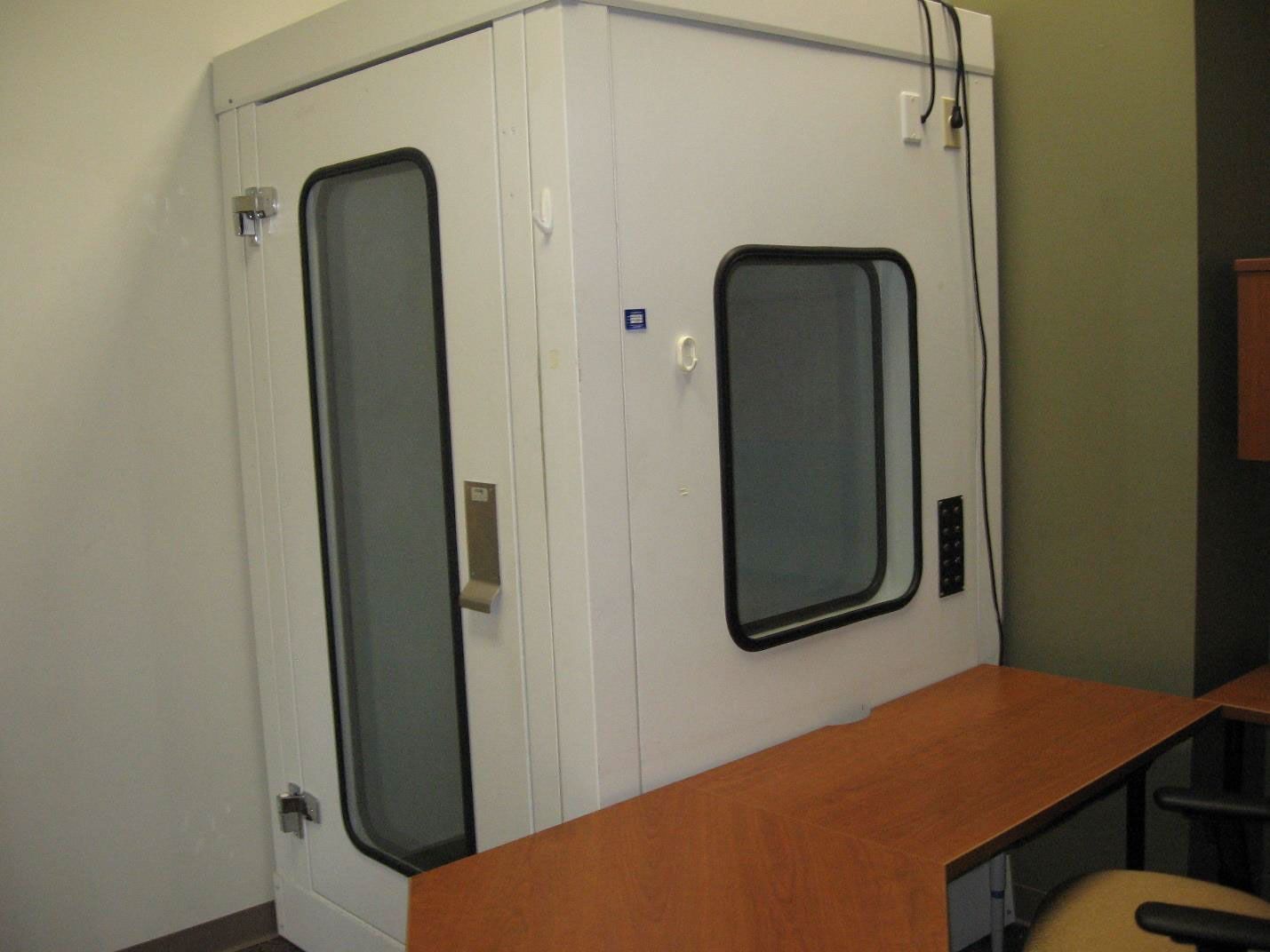 A small room with a white door and two windows