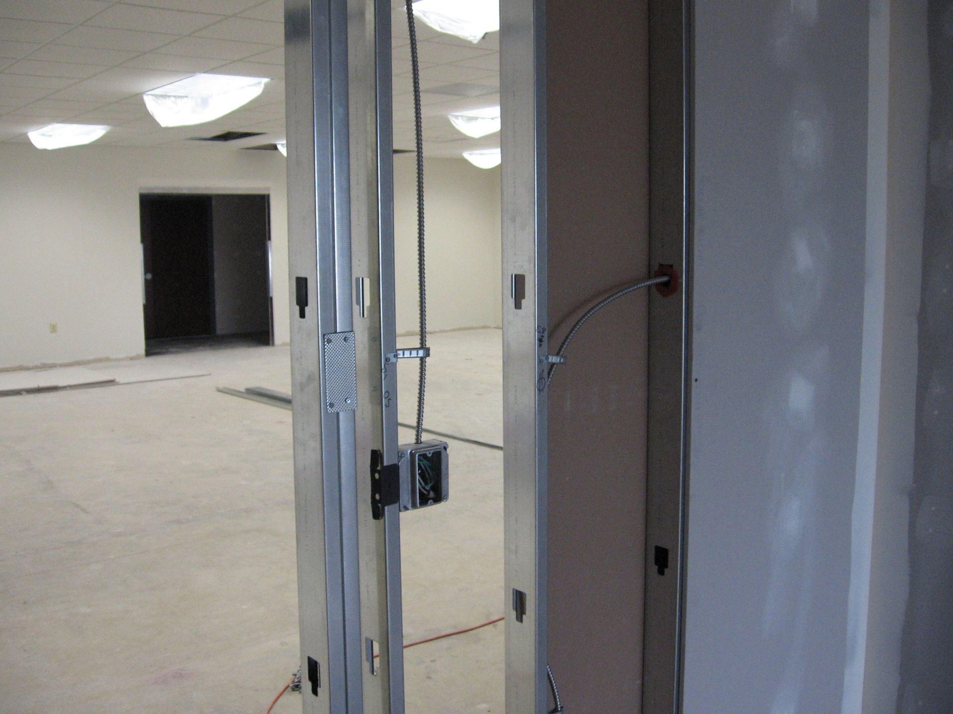 An empty room with a metal frame and electrical wires coming out of it.