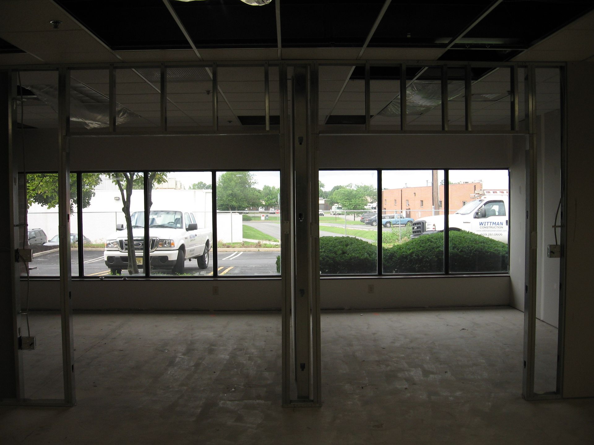 A white truck is parked in a parking lot in front of a building.