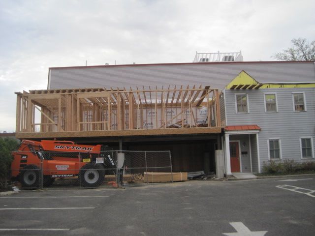 A jlg crane is parked in front of a building under construction.