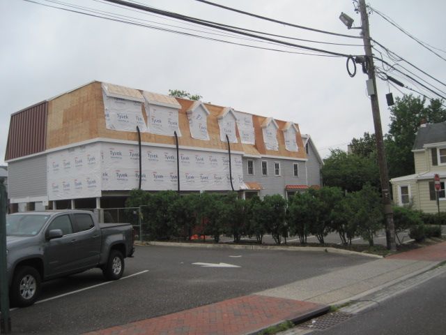 A truck is parked in front of a building under construction.