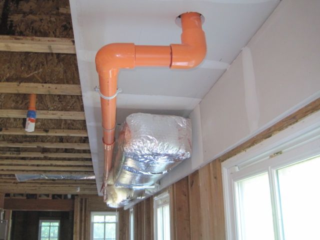 An orange pipe is hanging from the ceiling of a building.
