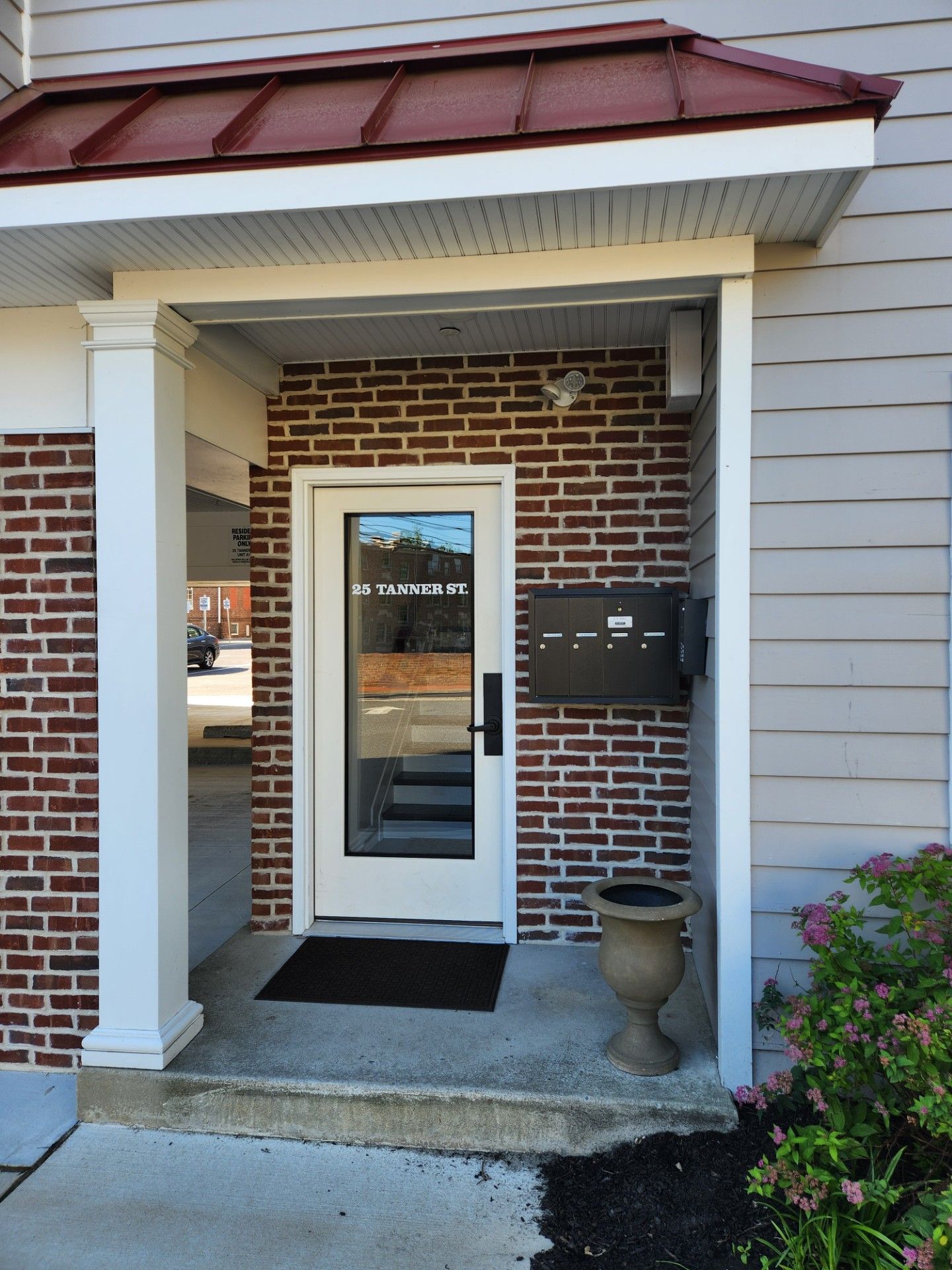 A brick building with a white door and a mailbox.