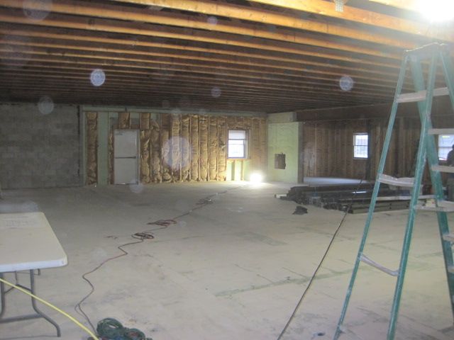 An empty room with a table and ladder in it.