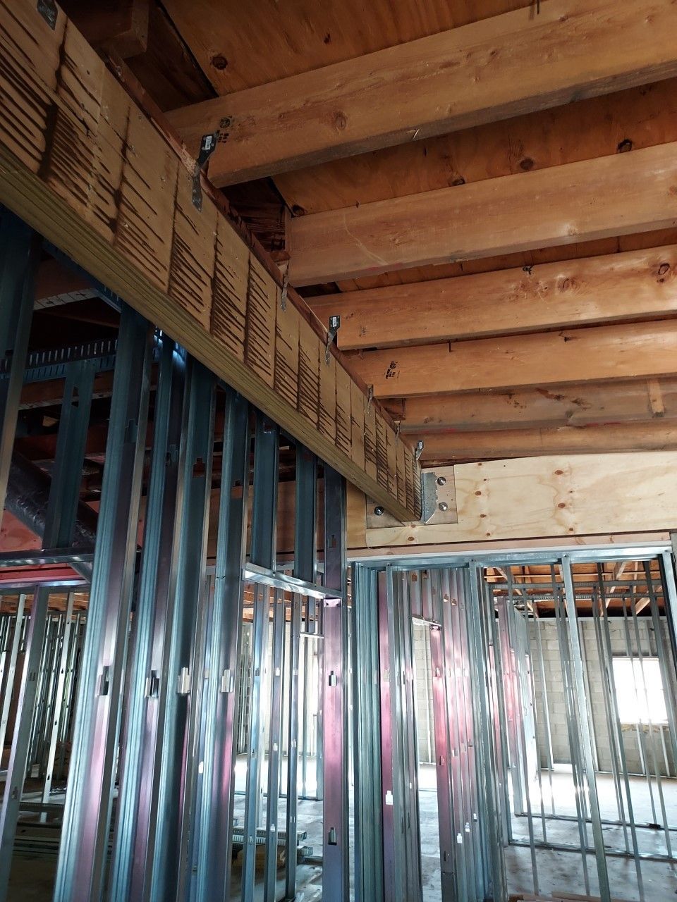 A building under construction with wooden beams and metal frames.
