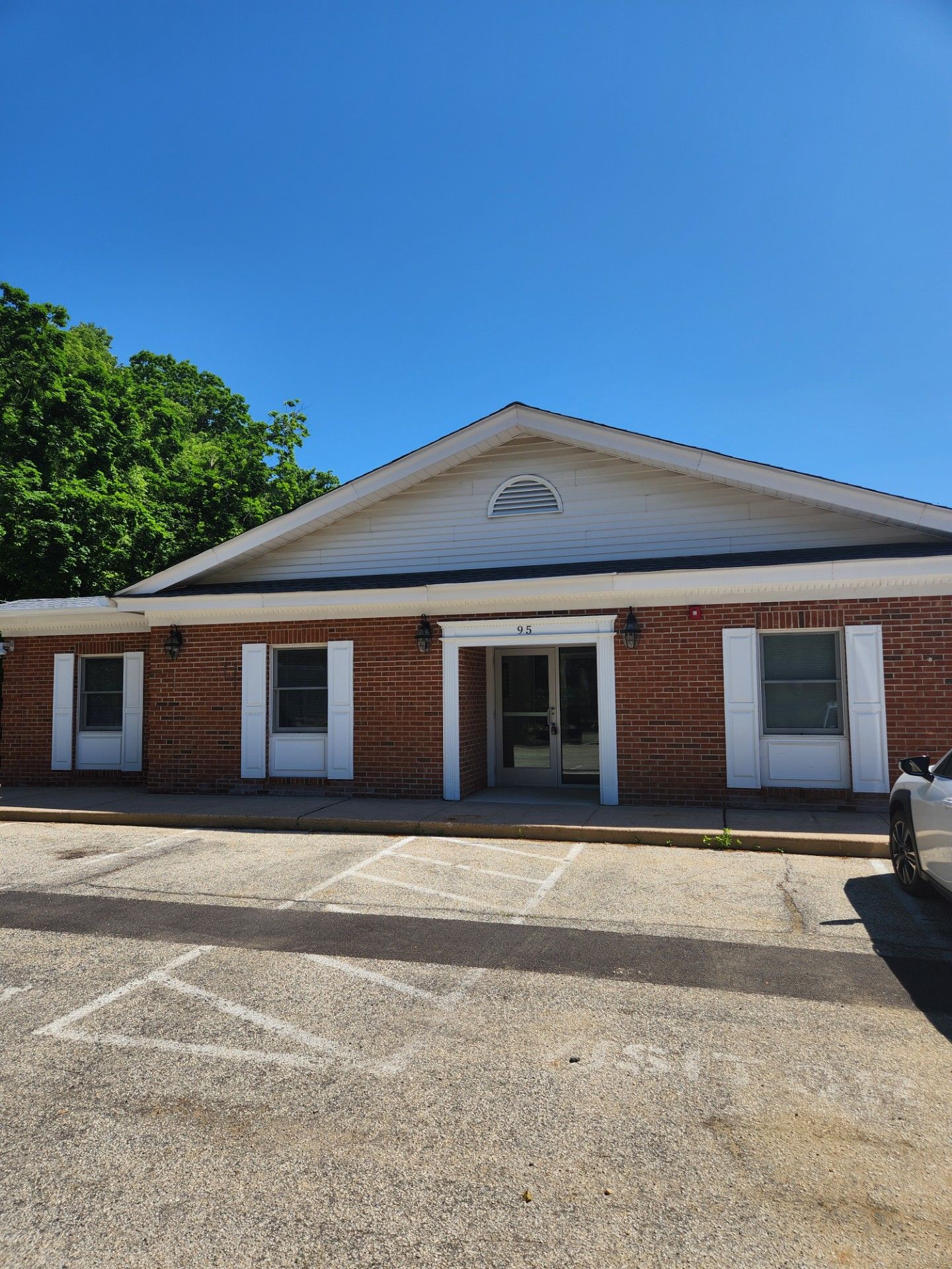 A white truck is parked in front of a brick building.