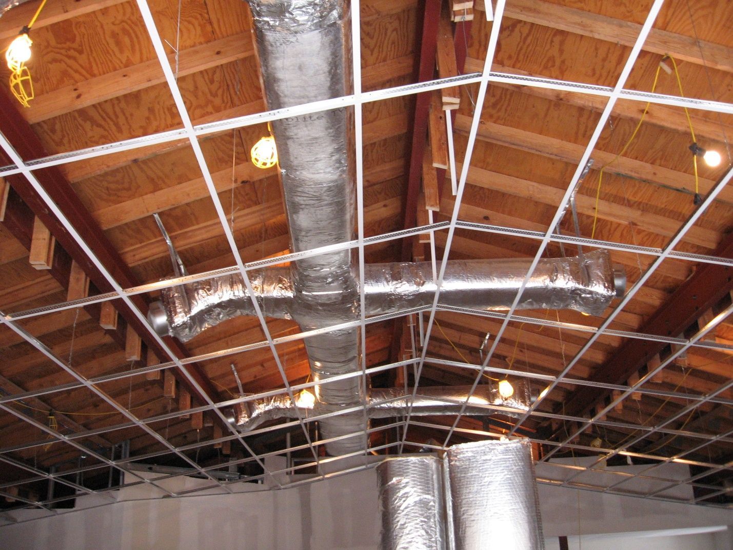 A ceiling with a lot of wires hanging from it.