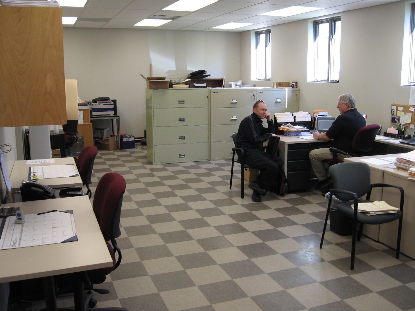 A man sits at a desk in an office.