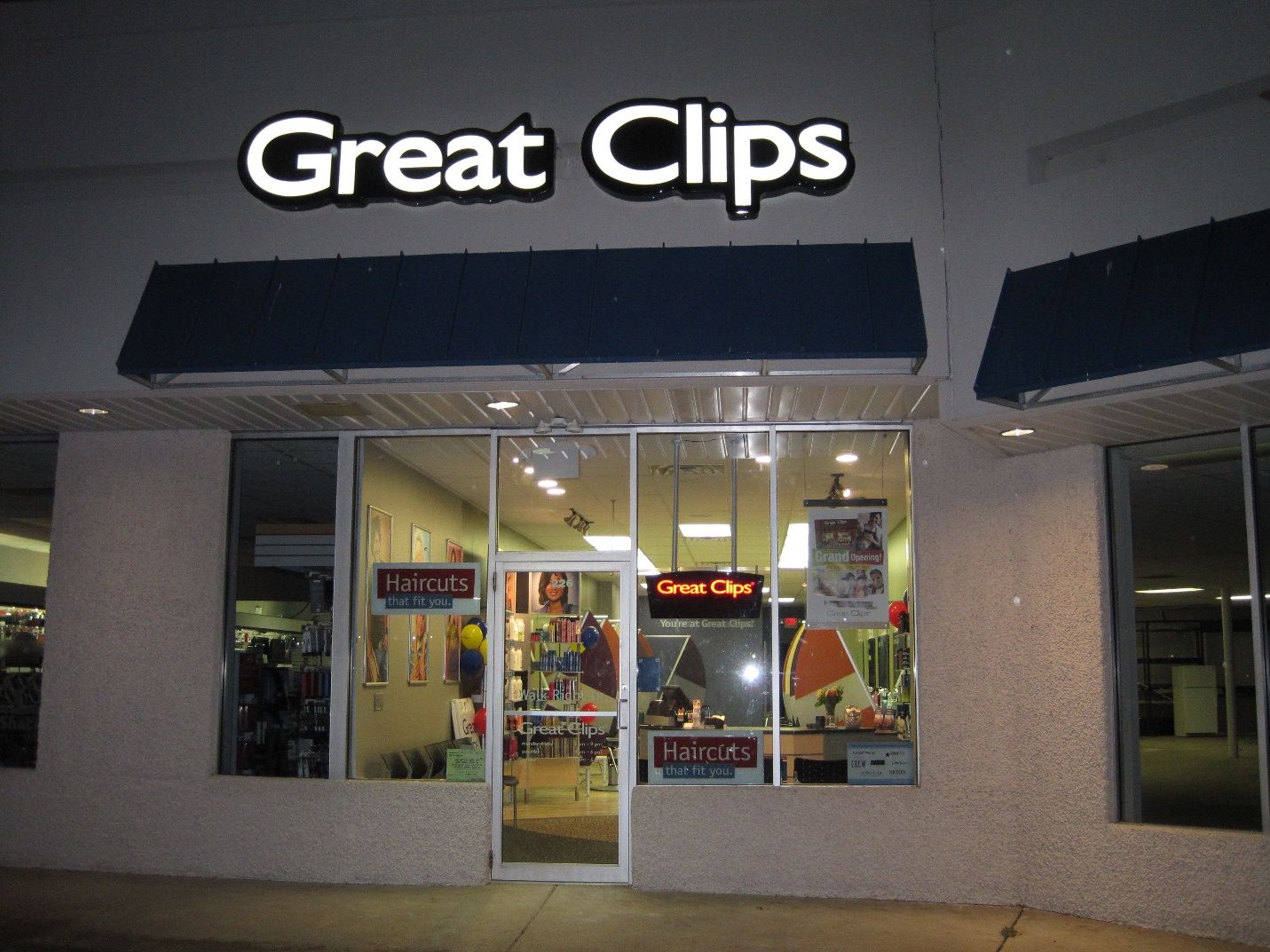 The front of a great clips store at night.