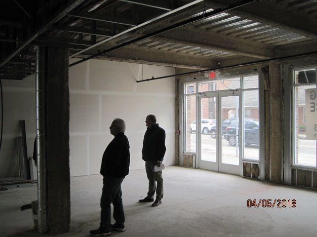 Two men standing in an empty room.