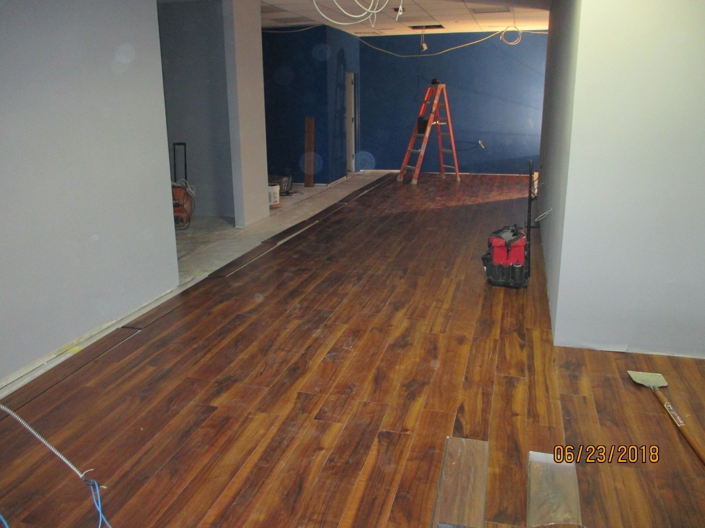 A room with hardwood floors and a vacuum cleaner on the floor.