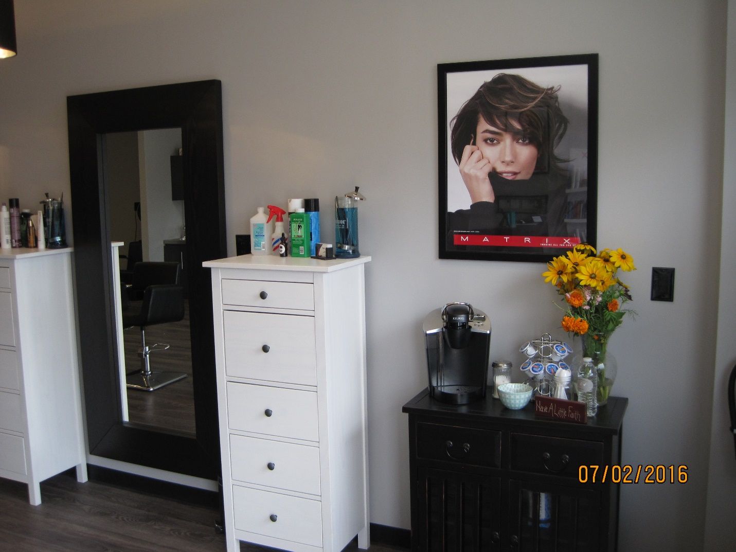 A picture of a woman is hanging on a wall in a room.