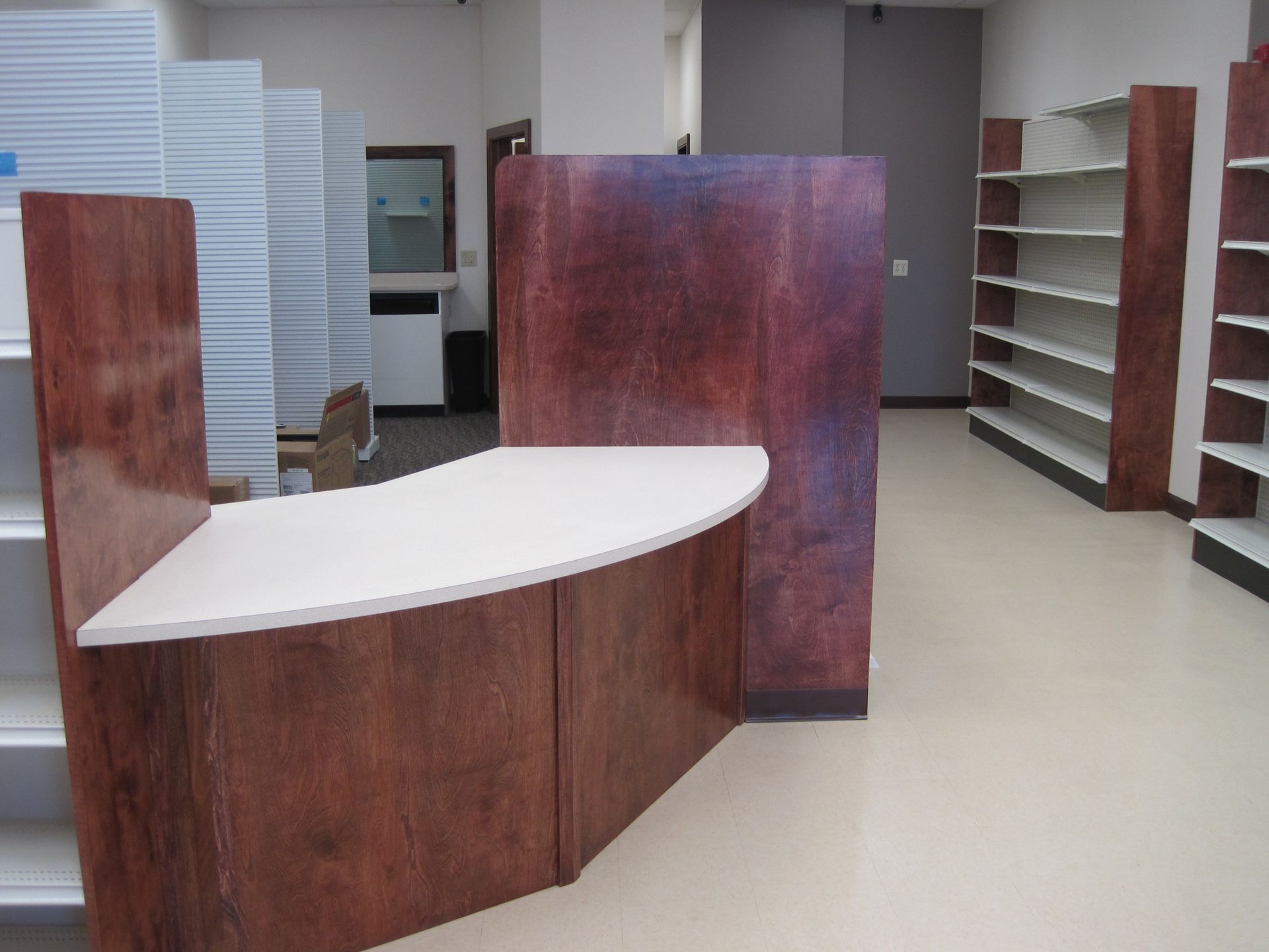A picture of an empty store with a wooden counter and shelves