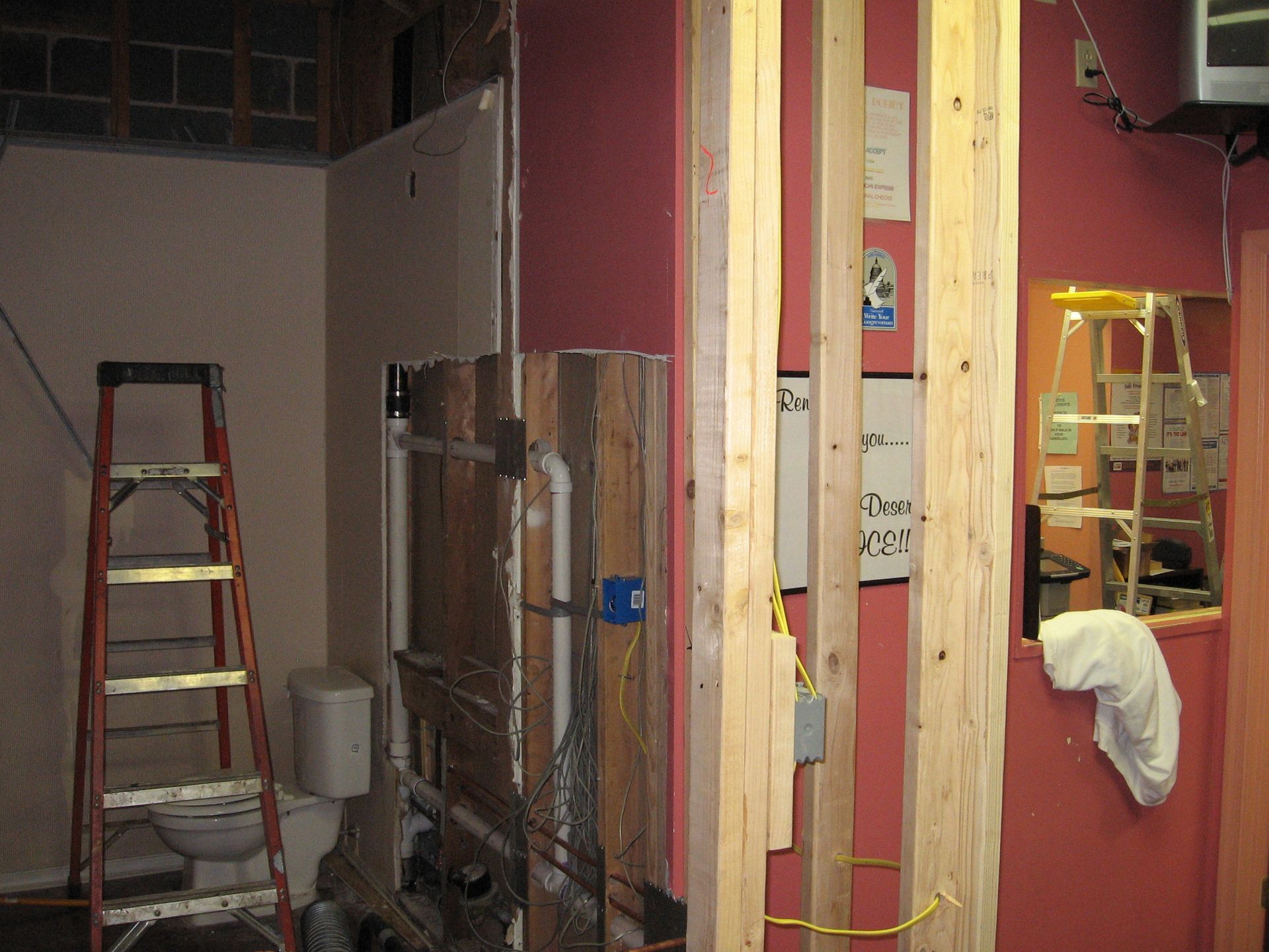 A bathroom under construction with a ladder and a toilet