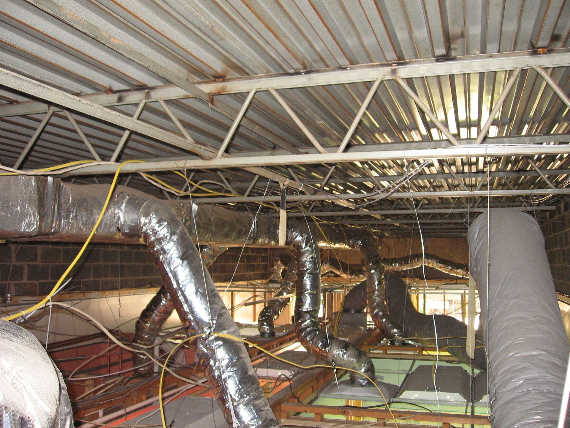 A bunch of pipes hanging from the ceiling of a building