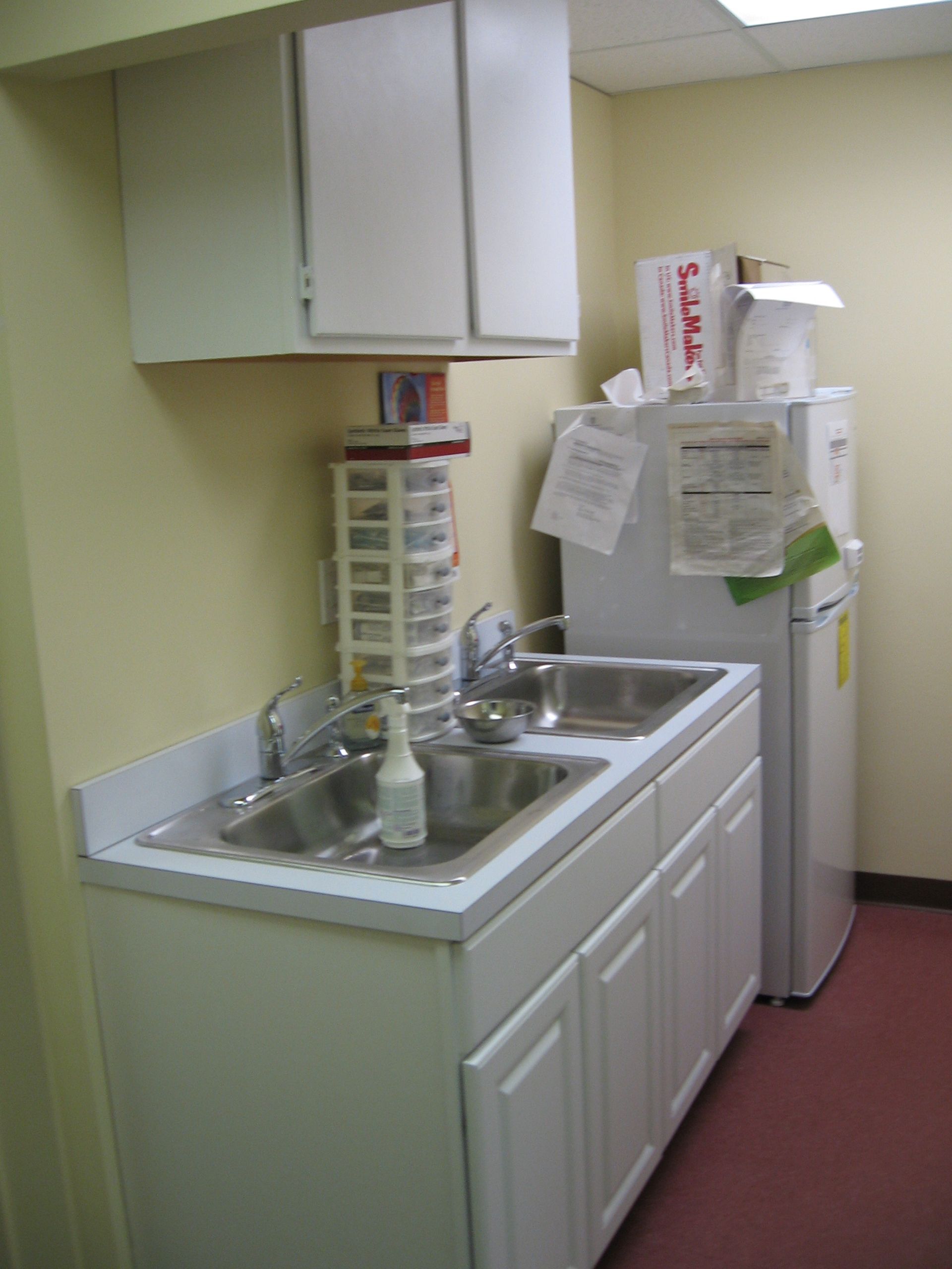 A small kitchen with a sink and a refrigerator