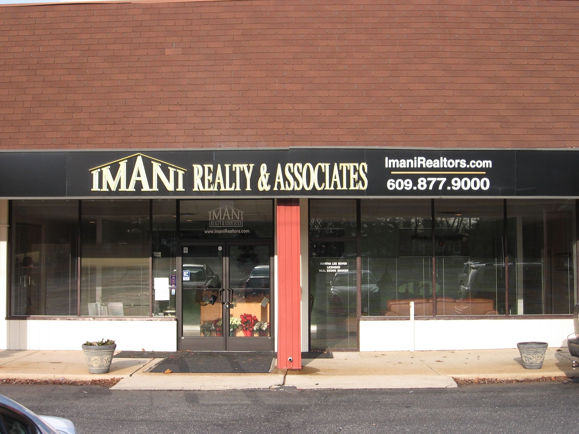 A building with a sign that says Imani Realty & Associates