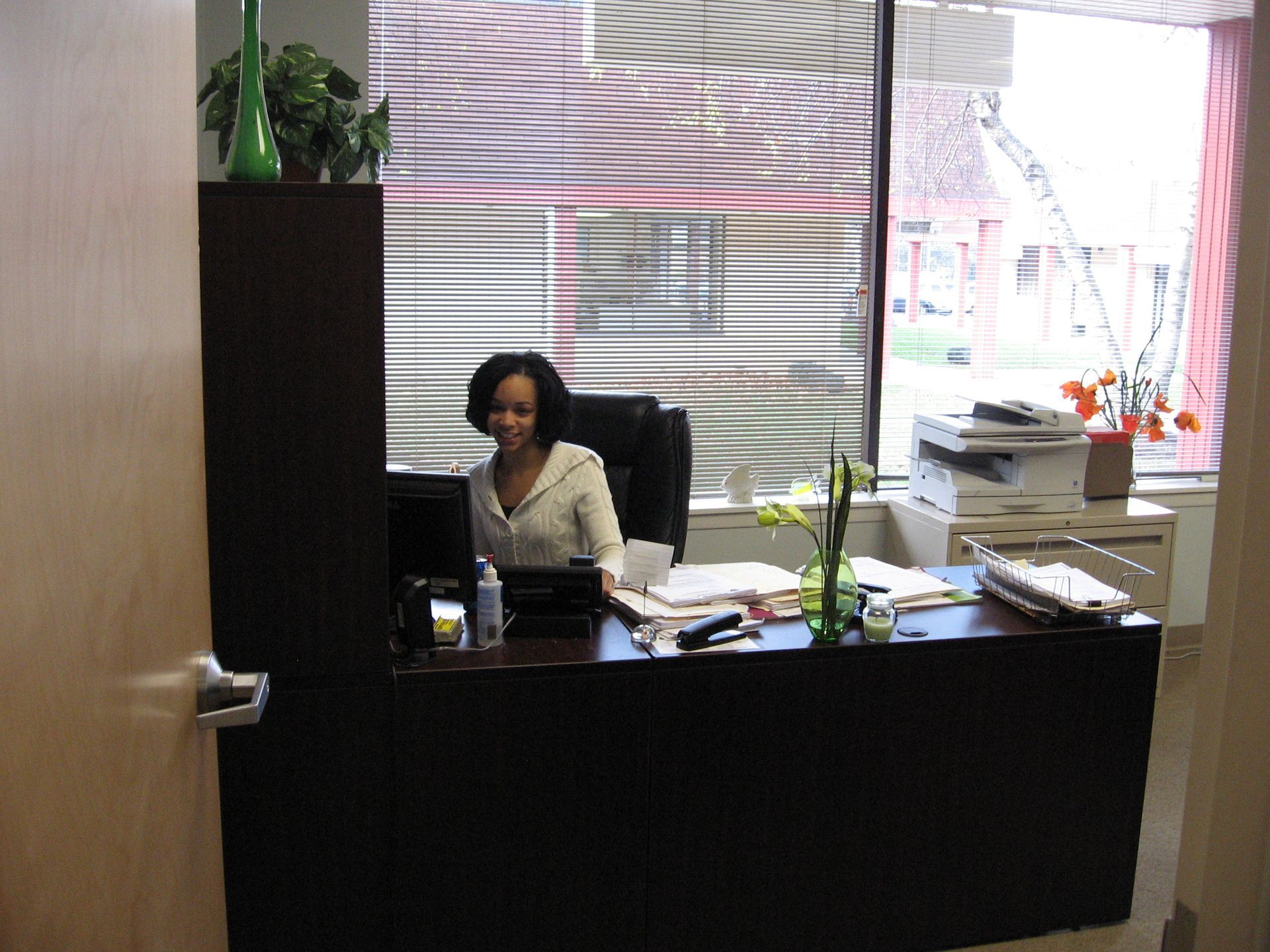 A woman is sitting at a desk in front of a computer