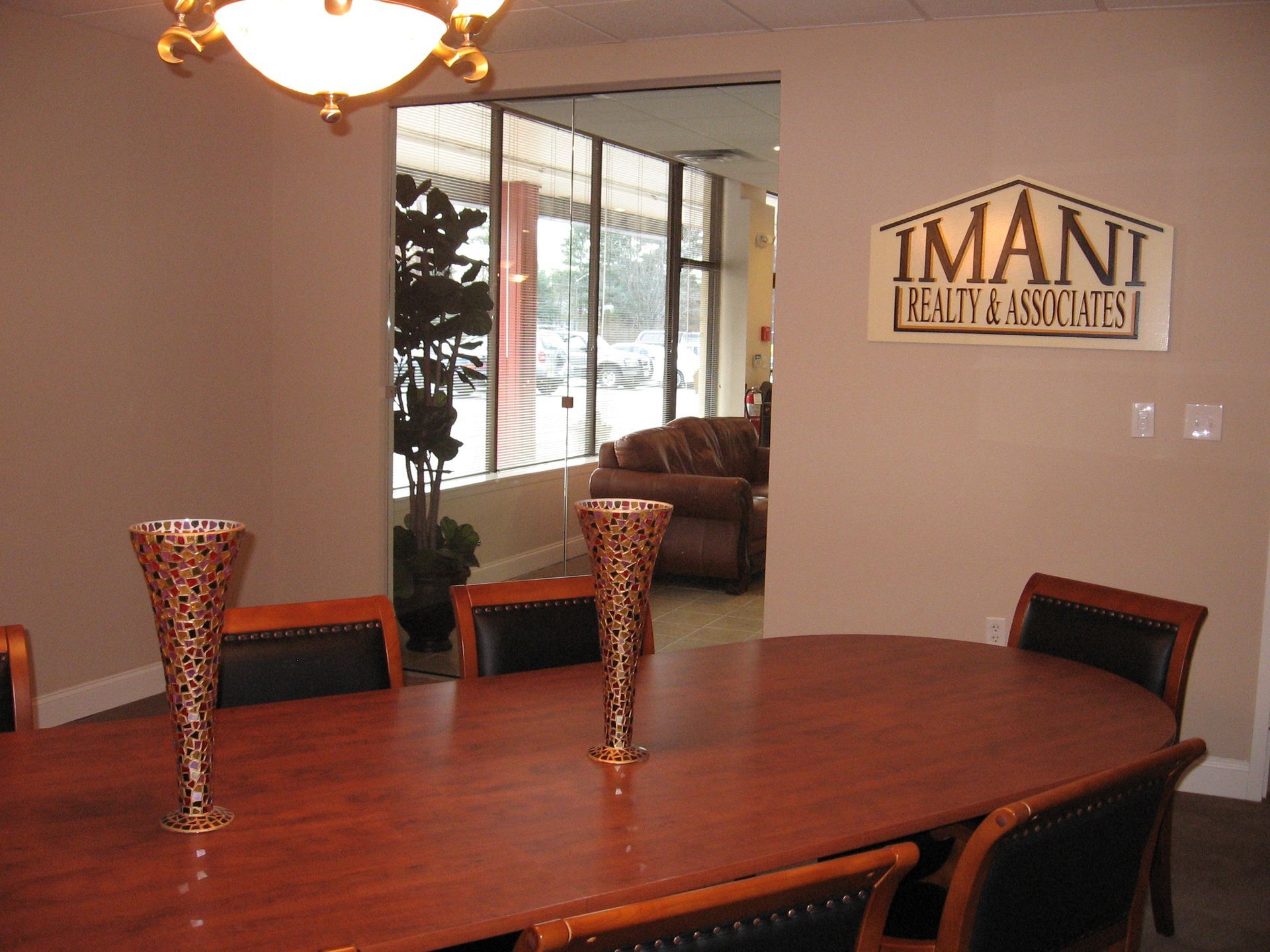 A room with a table and chairs and a sign that says Imani Realty Associates