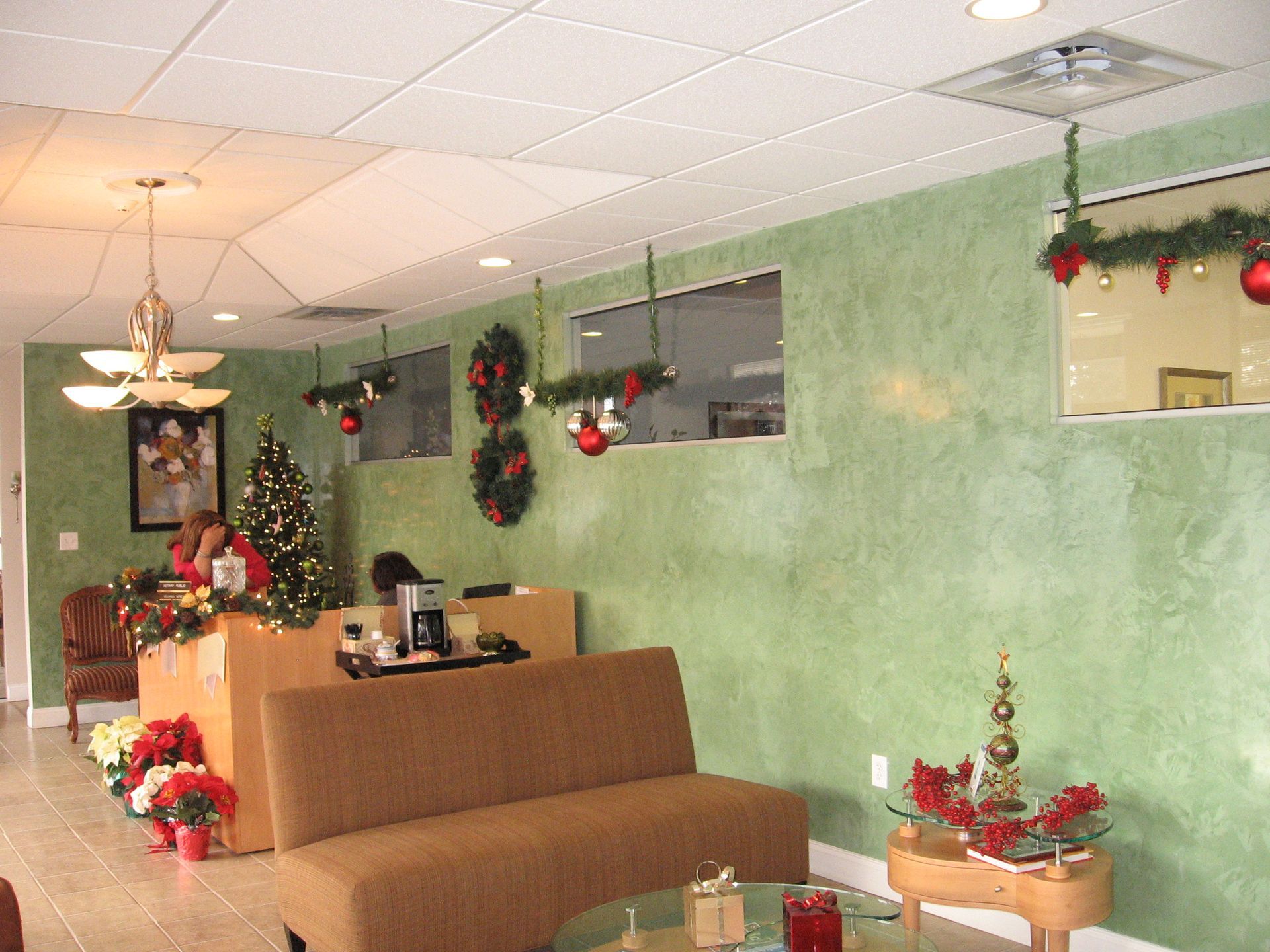 A waiting room decorated for christmas with a couch and a table