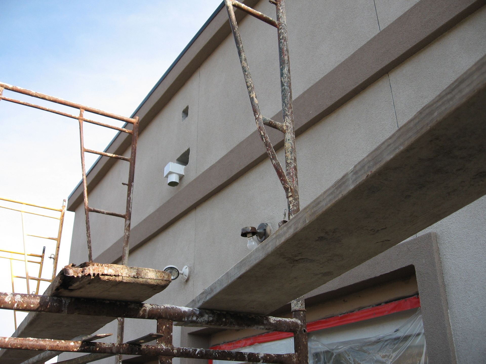A building under construction with scaffolding and a camera on the side