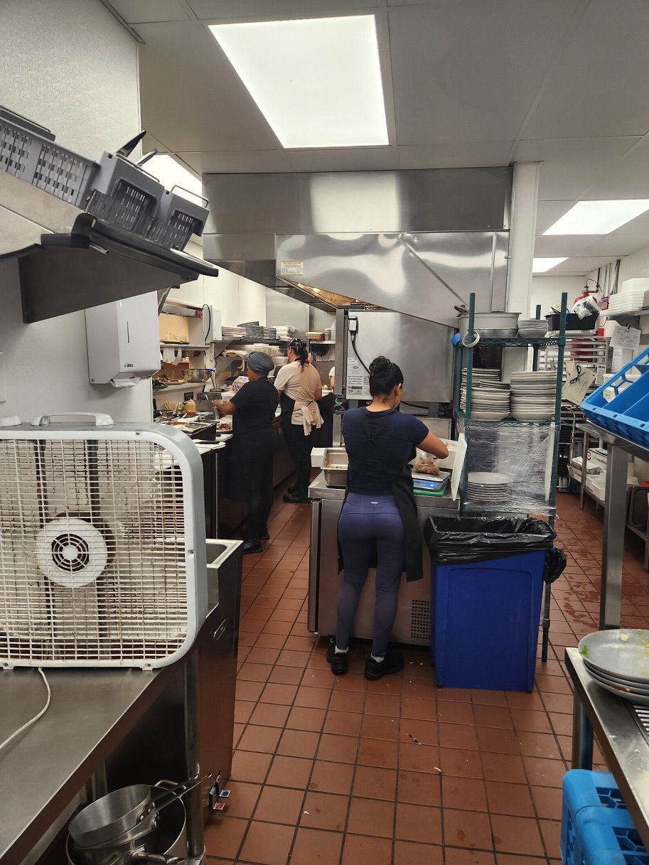 A woman is standing in a kitchen preparing food.