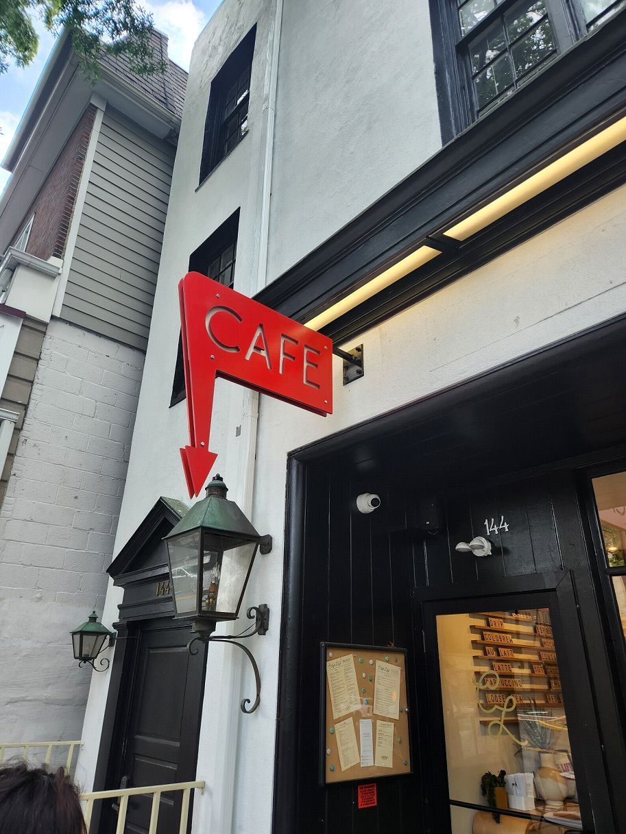 A red sign on the side of a building that says cafe