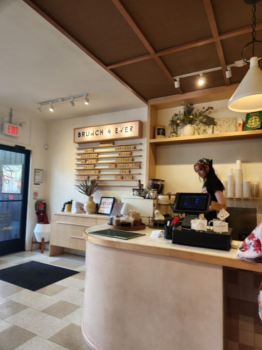 A woman is standing behind a counter in a restaurant.