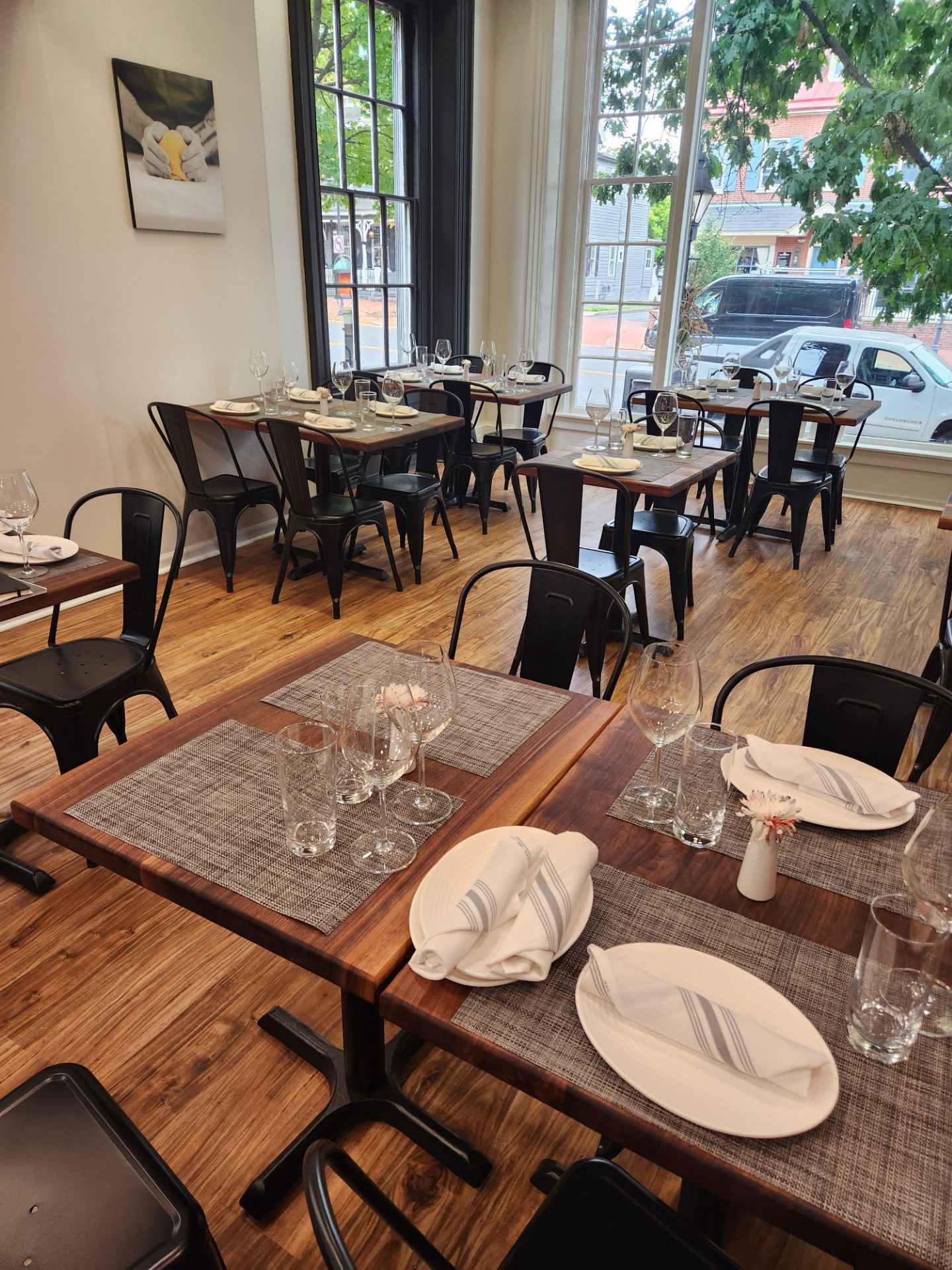 A restaurant filled with tables and chairs with plates and glasses on them.