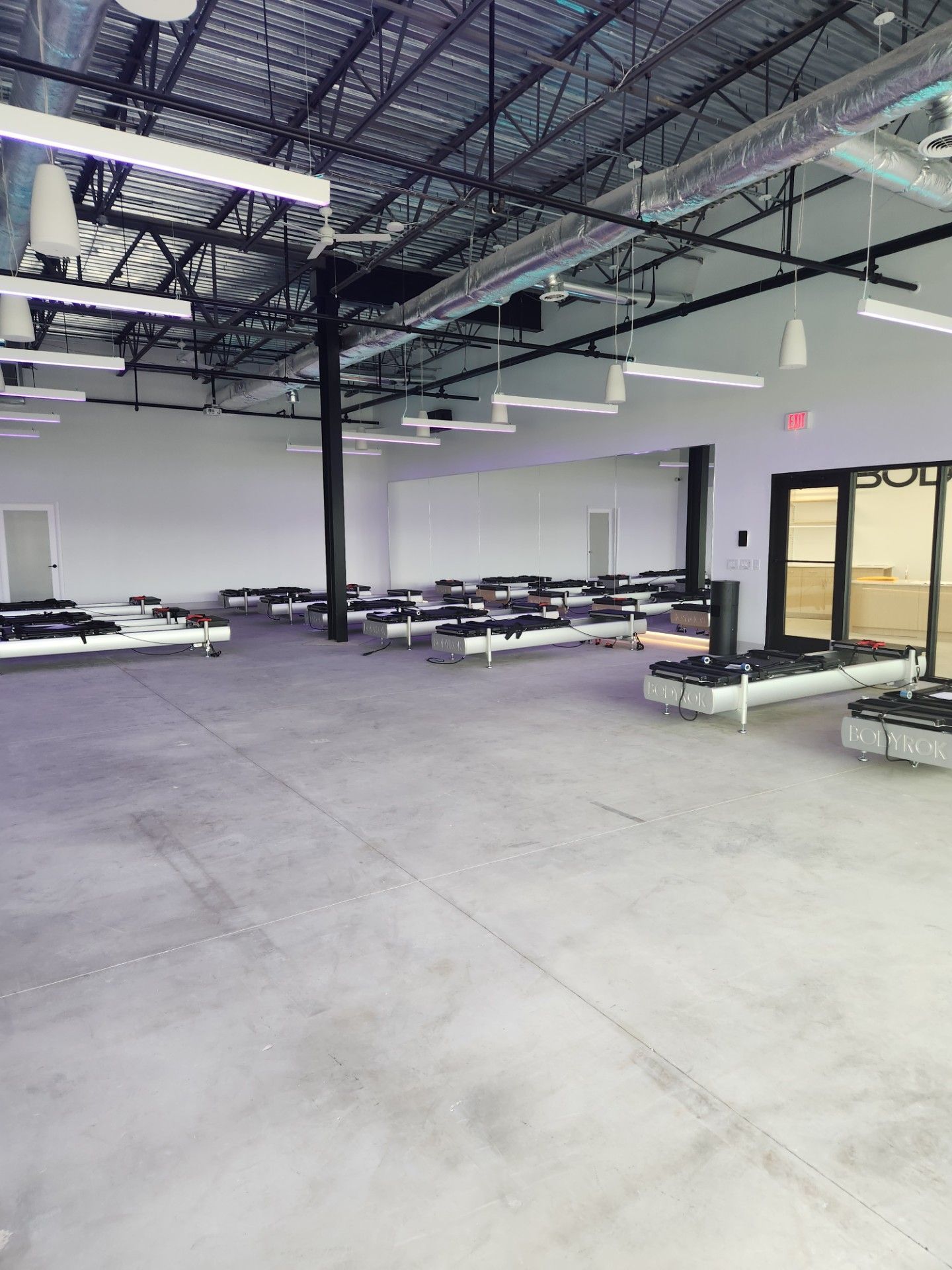A large empty room with tables and chairs in it.