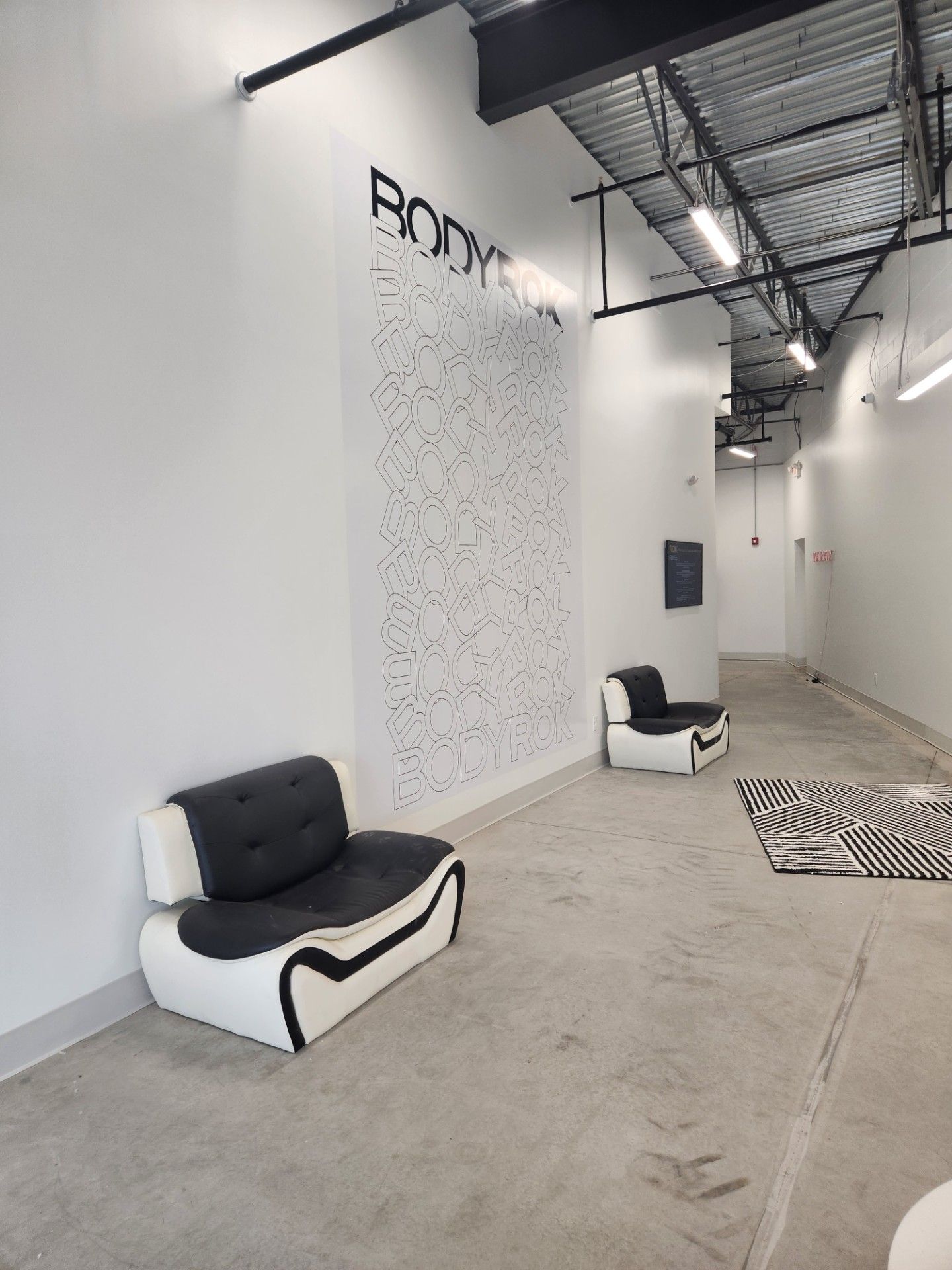 A room with two chairs and a wall that says body on it