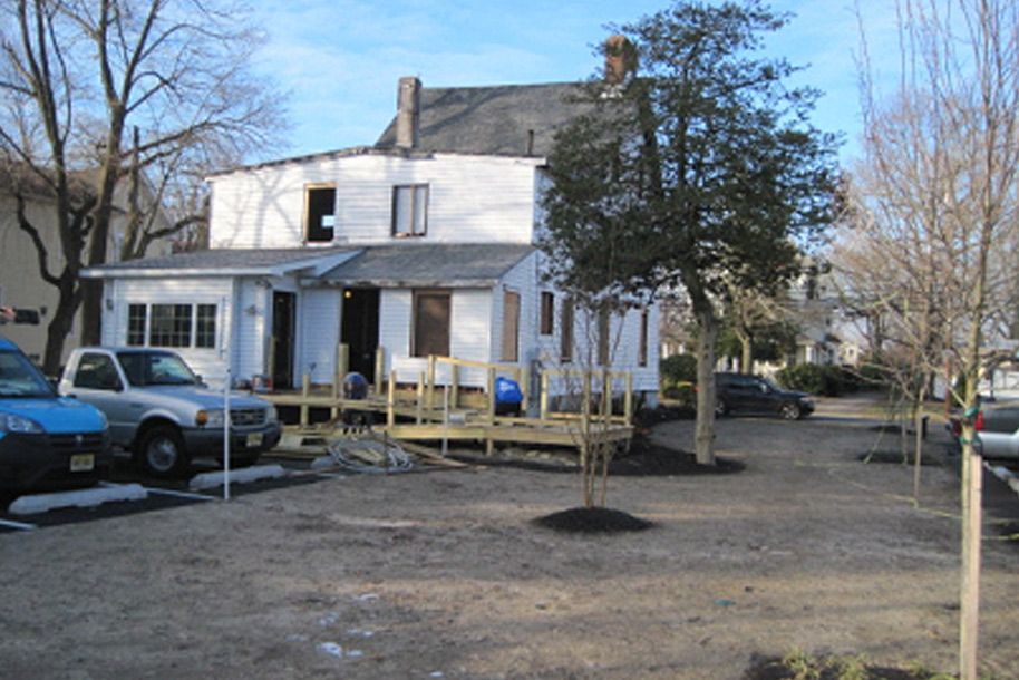 A white house with a wooden deck in front of it