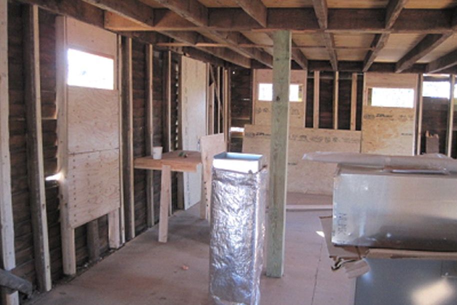 The inside of a building under construction with a metal pipe in the middle