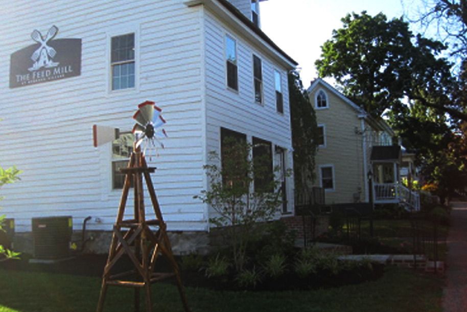 A white house with a windmill on the side of it