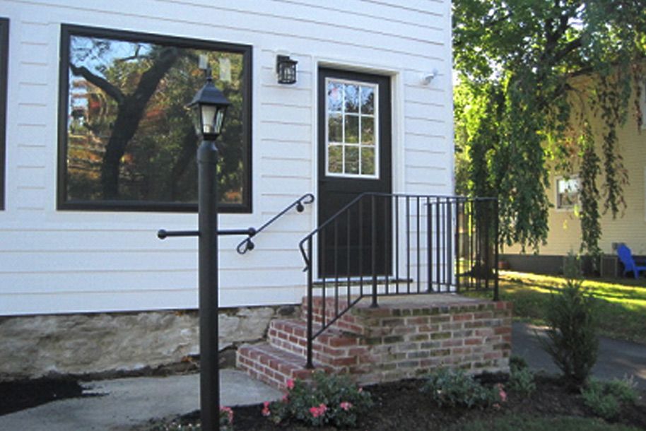 A white house with a black door and stairs
