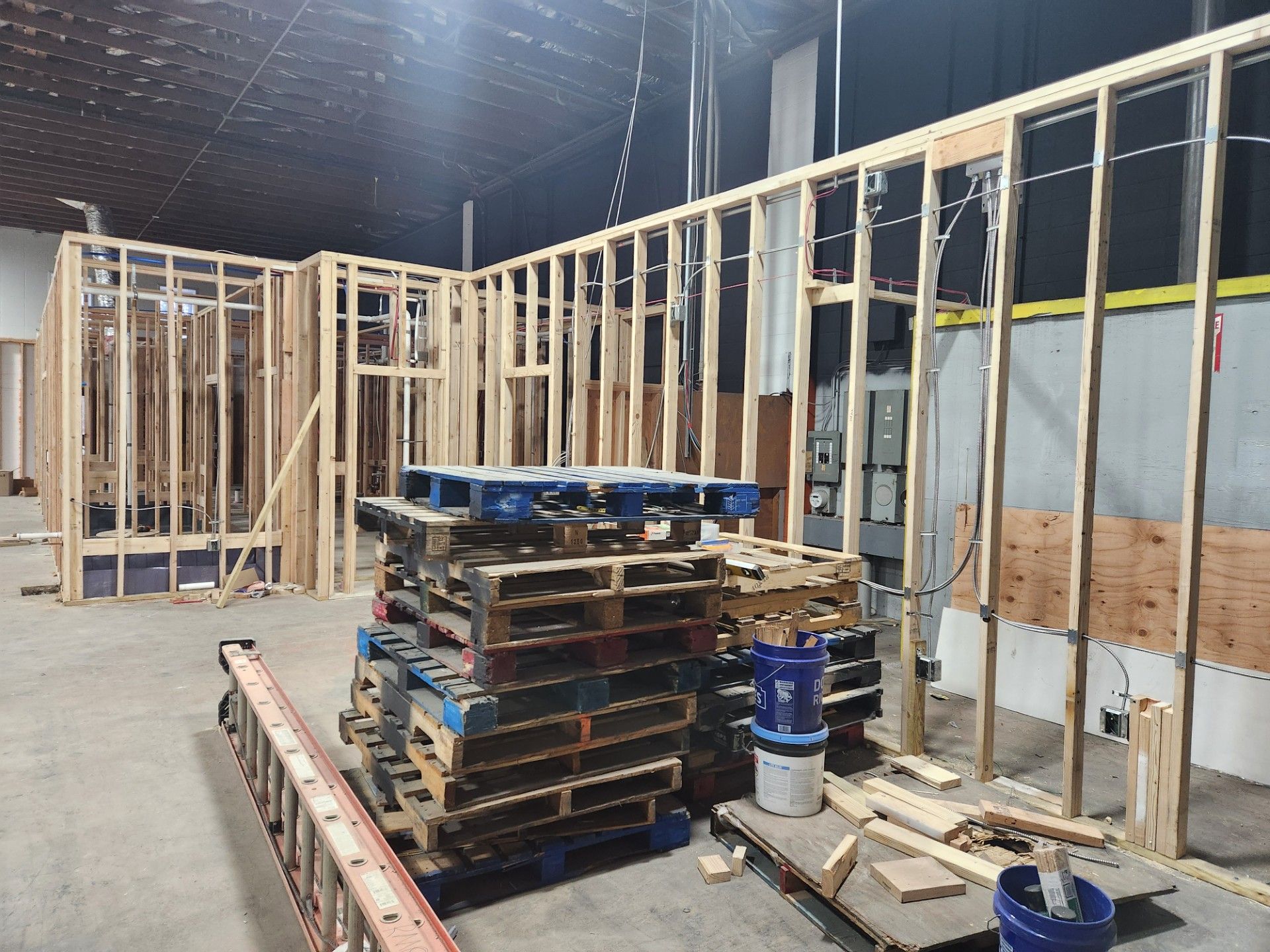 A warehouse under construction with pallets and a ladder
